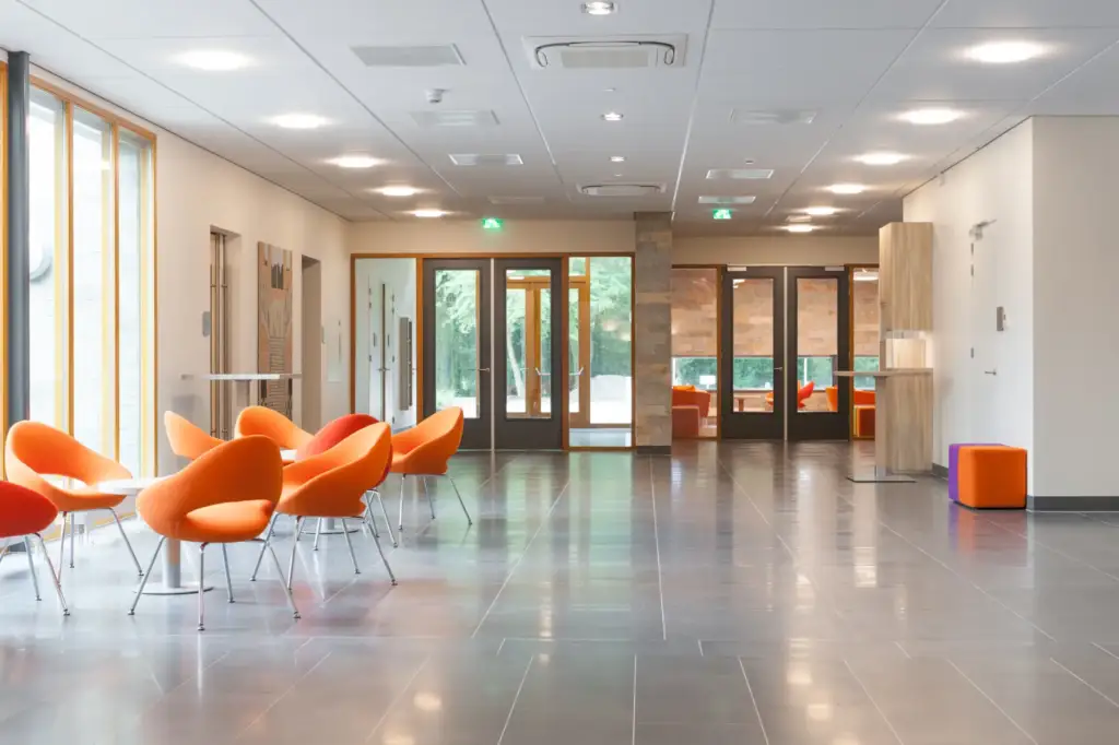 Lichte hal met oranje stoelen in Crematorium Heerhugowaard